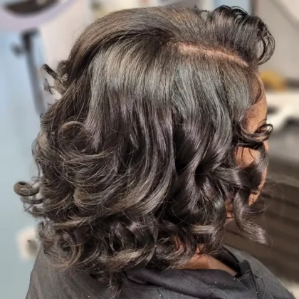 Voluminous curls and blowout styling on natural dark hair at Millionaire Hair Salon Winter Garden FL